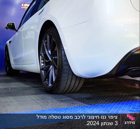מכונית לבנה עם גלגלים שחורים על רצפת מוסך